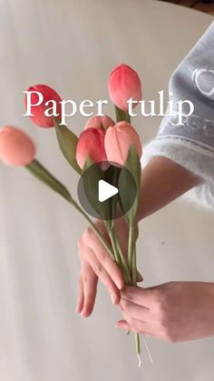 a person holding flowers with the words paper tulip on it