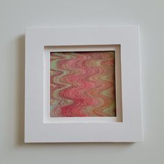 a square white frame with a multicolored pattern in the center and an opening at the bottom