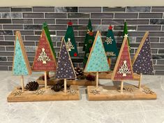 small wooden christmas trees on display in front of a brick wall