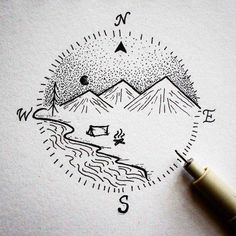 a pen is sitting on top of a piece of paper that has a drawing of mountains in it