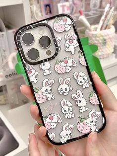 a person holding up an iphone case with bunny and rabbit images on the back in front of them