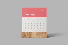 a desk calendar with a wooden block on it's side and the word january written in white