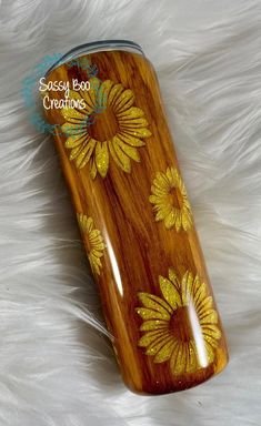 a wooden canister with yellow flowers painted on it sitting on a white furnishing