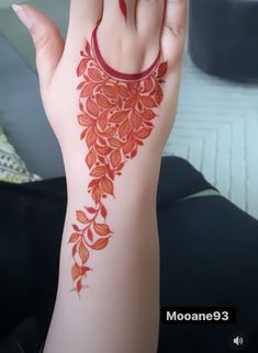 a woman's hand with a red tattoo on it