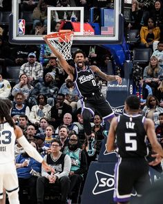 a basketball player is jumping up to dunk the ball in front of an audience