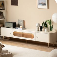 a living room with a white entertainment center and bookshelf filled with various items