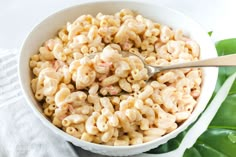 a bowl filled with macaroni and cheese on top of a white table cloth