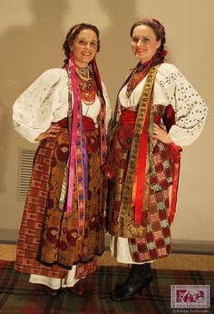 two women dressed in traditional clothing standing next to each other with their hands on their hips