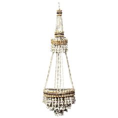 a chandelier hanging from the ceiling with beads and chains on it's sides