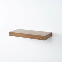 a wooden shelf mounted on the wall with no one around it or in front of it