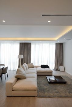 a modern living room with white furniture and curtains