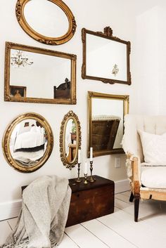 a white space with a creamy chair, a dark chest with decor and a refined mirror gallery wall with mirrors in gold frames Romantic Antique Bedroom, Antique Room Ideas Bedrooms, Interior Antique Modern, Bedroom Antique Decor, Antique Guest Bedroom, Cozy Antique Bedroom, Vintage Antique Decor, Modern Antique Bedroom, Antique Room Ideas