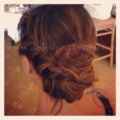 the back of a woman's head, with wavy hair in a low bun