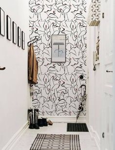 the hallway is decorated in black and white with an abstract wallpaper pattern on it