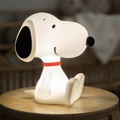 a snoopy lamp sitting on top of a wooden table