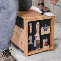 a man is working with tools in his workbench on the floor while sitting down