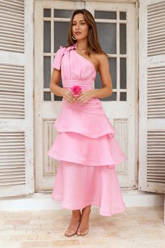 Length from shoulder to hem of size S: 120cm. Chest: 36cm, Waist: 30cm, across front only of size S. Midi dress. Semi-lined. Model is a standard XS and is wearing size XS. True to size. Non-stretch. One shoulder tie-up. Tiered frill flowy skirt. Zipper. Cold hand wash only. Nylon/Rayon/Linen/Tencel. Earn your style points in the Events In The Garden One Shoulder Midi Dress. Featuring a tie-up shoulder strap and a gorgeous tiered frill flowy skirt. Style with sandals for a look that will take you through the day looking gorgeous. Elegant Pink Maxi Length Ruffle Dress, Spring Garden Party Pink Tiered Dress, Formal Garden Party Attire, Garden Party One-shoulder Maxi Dress With Ruffles, Pink One-shoulder Midi Dress For Garden Party, Pink A-line Midi Dress With Ruffles, Long Ruffle Dress, Midi Dress Pink, Derby Dress