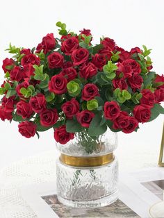 a vase filled with red roses on top of a table