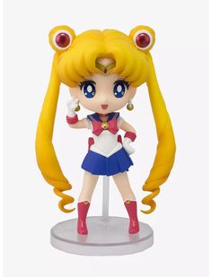 sailor moon figurine with blonde hair and blue eyes, standing on a white surface