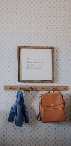 two purses are hanging on the wall next to a coat rack with a sign above it