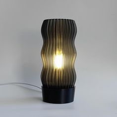 a lamp that is sitting on top of a white surface with a light shining through it