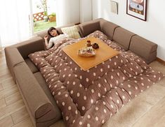 a person laying on top of a couch in front of a table with coffee cups