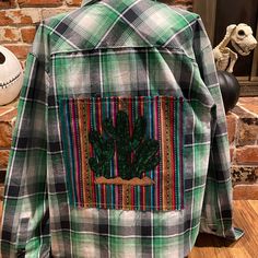 a green plaid jacket with a cactus patch on it