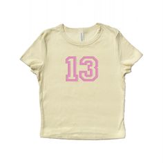 Baby tee with 13 embroidered in pink polyester thread. Available in natural, black, and light blue. A thoughtful gift for your pop music loving bestie. <3 Soft, mid-length shirt for the perfect baby tee fit! Fabrication: 52% Airlume combed and ring-spun cotton, 48% polyester 32 single, 5.4oz Want a different embroidery color? Message us! We have a large variety of colored thread to choose from. Lucky 13, Baby T Shirts, Music Love, Graphic Tees Women, Infant Tees, Womens Clothing Tops, Light Blue, Favorite Outfit, Graphic Tees