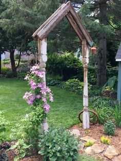 an old wooden arbor with flowers growing out of it's sides in a garden