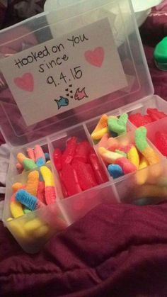 two plastic containers filled with candy on top of a bed