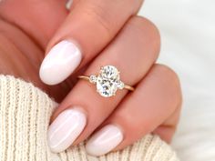 a woman's hand with white manicured nails and a ring on her finger