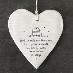 a ceramic heart hanging on a wall with a poem written in the shape of a house