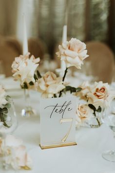 the table is set with flowers and place cards for guests to sit down at it