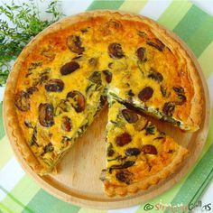 a cheese and vegetable quiche on a wooden platter