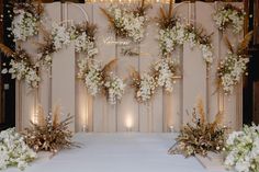 a white table topped with lots of flowers and greenery next to a chandelier