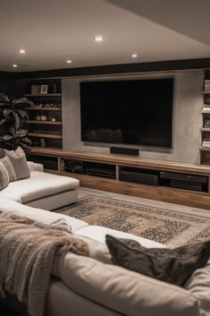 a living room with couches and a flat screen tv mounted on the wall above it