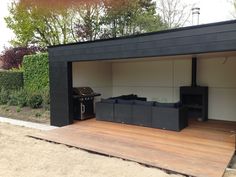 an outdoor living area with couches and grill