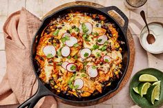 a skillet filled with mexican food and garnished with sliced radishes