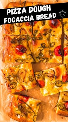 pizza dough with tomatoes, cheese and herbs cut into squares on a sheet of wax paper