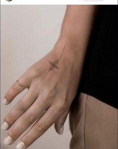 a woman's hand with a small star tattoo on it