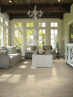 a living room with two couches and a chandelier hanging from the ceiling