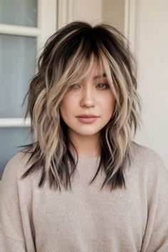 Woman with layered, shoulder-length hair featuring dark roots and blonde highlights. Medium Length Edgy Hair, Medium Haircuts Women, Choppy Edgy Hair, Rockstar Shag Haircut, Edgy Long Haircut, Wolf Haircut Woman, Wolf Cut For Women, Shag With Highlights, Shaggy Lob For Fine Hair