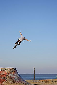 a man flying through the air while riding a skateboard on top of a ramp