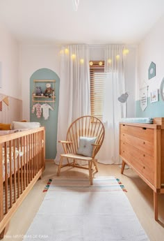 a baby's room with a rocking chair, dresser and crib in it