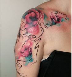 a woman's shoulder with flowers painted on her arm and the upper half of her body