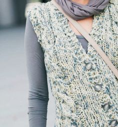 a woman is wearing a scarf and holding a cell phone