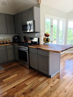 a kitchen with wooden floors and gray cabinets