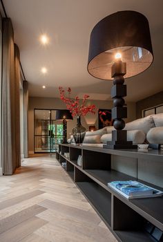 a living room filled with lots of furniture and a tall lamp on top of a table