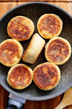 some food is cooking in a frying pan on a table with utensils