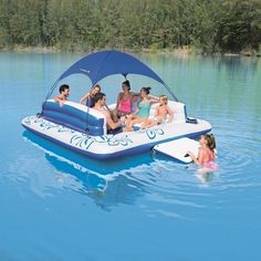 a group of people riding on the back of a blue boat in a body of water